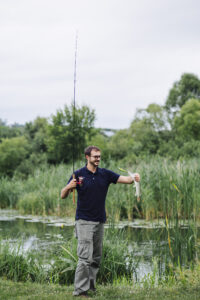 Homme souriant, regardant le poisson fraîchement pêché
